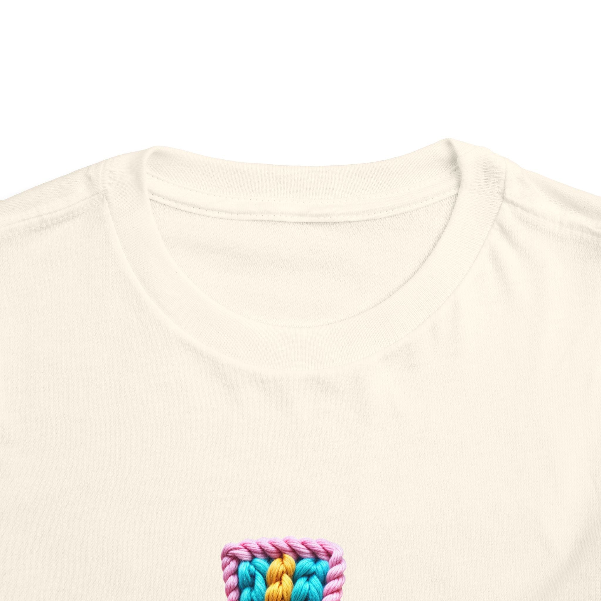 Easter Cross Toddler Tee — Colorful Knit Cross with "He is Risen" & Easter Eggs