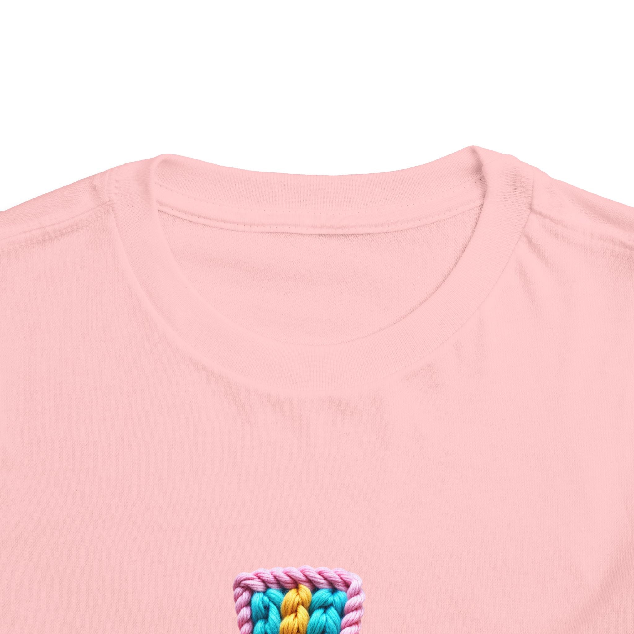 Easter Cross Toddler Tee — Colorful Knit Cross with "He is Risen" & Easter Eggs